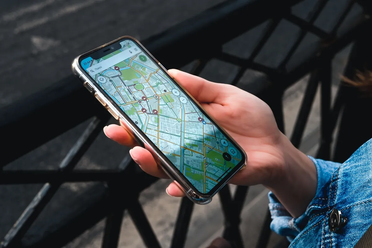 Hand holding a smartphone showing a map app